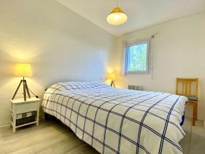 a bedroom with a large bed and a window at REF 042 Appartement T2 avec balcon et piscine Arzon in Arzon