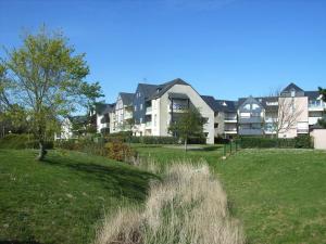 a large apartment building in a field with grass at REF 042 Appartement T2 avec balcon et piscine Arzon in Arzon