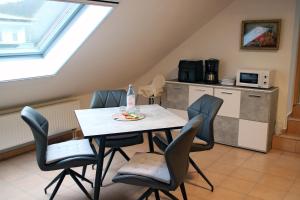 a dining room with a table and chairs and a kitchen at Fewo an Sorpe in Sundern
