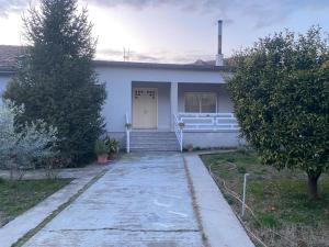 a white house with a white door and stairs at Luxury House in Shkodër