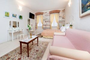 a large bedroom with a pink bed and a desk at The Palace RoomS in Rovinj