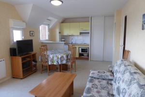 阿尔宗REF 088 Appartement T2 vue port Crouesty proche commerces的带沙发和桌子的客厅和厨房