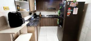 a kitchen with a black refrigerator and a sink at Casa campestre Magyli in Puerto Salgar