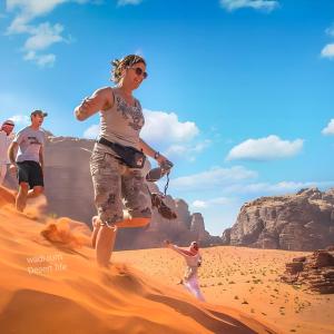 a group of people running through the desert at wadi rum Desert life in Disah +122 photos