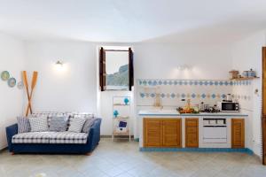 a living room with a blue couch and a kitchen at La Cabane Bleue in Nerano