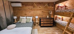 two beds in a room with wooden walls at Essencia, gîte dans les collines de Toulon in Toulon
