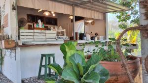 an outdoor kitchen with a bar in a garden at Kradandam Home & Cafe in Phitsanulok