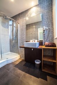 a bathroom with a toilet, sink, and shower at Hotel Kanaï in Lille