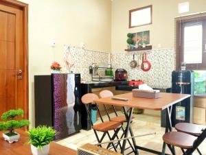 a kitchen with a table and a refrigerator at Brojos Homestay near Malioboro in Yogyakarta