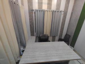 a room with curtains and a table and chairs at SHARVIL Inn in Lucknow