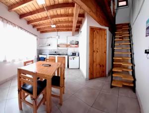 a kitchen with a wooden table and a staircase at La Cantonada, alojamiento turístico, Caviahue in Caviahue