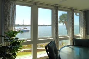 a window with a table and a boat in the water at Surf and Turf in Folly Beach +23 photos