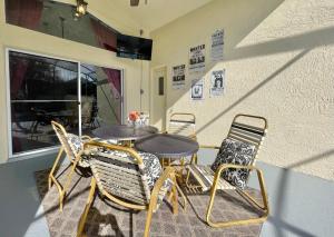 Un patio con una mesa y sillas y una ventana. en Magical 5-Bedroom Villa Near Universal's Wizarding World, en Kissimmee
