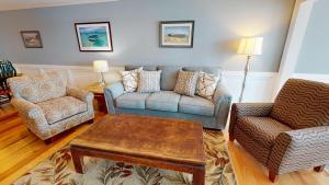 a living room with a couch and two chairs and a table at Surf and Turf in Folly Beach