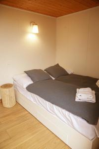 a bedroom with a large bed with a light on it at Black & White Cekcyn Bory Tucholskie in Cekcyn