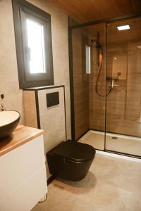 a bathroom with a black toilet and a shower at Black & White Cekcyn Bory Tucholskie in Cekcyn