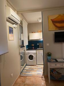a small kitchen with a washing machine and a washer at Meublé tourisme Carmes 2 étoiles, entrée autonome,wifi, climatisé, petit parking privé in Toulouse