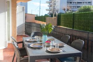 a table with plates and glasses on a balcony at WELCS APARTAMENTO 204 PDA junto al mar in L'Estartit