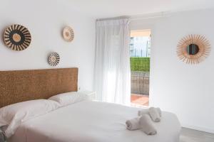 a white bed with two stuffed animals on top of it at WELCS APARTAMENTO 204 PDA junto al mar in L'Estartit