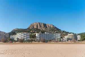 a mountain in the background of a beach with buildings at WELCS APARTAMENTO 204 PDA junto al mar in L'Estartit