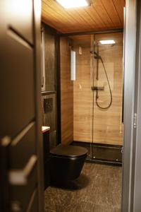 a bathroom with a black toilet and a shower at Black & White Cekcyn Bory Tucholskie in Cekcyn