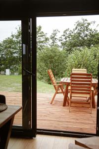 a patio with a table and chairs on a deck at Black & White Cekcyn Bory Tucholskie in Cekcyn