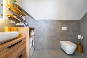 a bathroom with a sink and a washing machine at Podkrovní apartmán Studnice in Nové Město na Moravě +5 photos