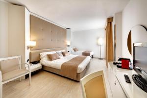 a hotel room with a bed and a television at Mediterraneo Palace Hotel in Ragusa