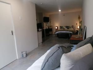 a living room with a couch and a table at 1-On-Scott Garden Suites in Somerset East