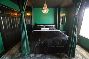 a bedroom with a bed with green walls and a chandelier at Waterfront 6-Bedroom Wizarding Villa in Lake Berkley Near Universal Studio's Harry Potter in Kissimmee +119 photos