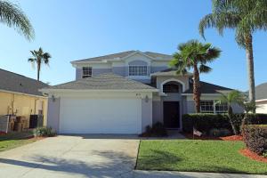a white house with a garage and palm trees at Waterfront 6-Bedroom Wizarding Villa in Lake Berkley Near Universal Studio's Harry Potter in Kissimmee