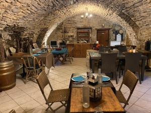 a restaurant with tables and chairs in a stone building at Domaine d'Alcapiès in Saint-Jean-dʼAlcapiès