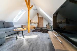 a living room with a couch and a table at Podkrovní apartmán Studnice in Nové Město na Moravě