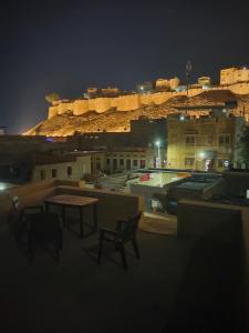 un tavolo e sedie sul tetto di un edificio di notte di Jaisalmer Rosu Safari a Jaisalmer