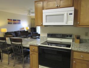a kitchen with a stove and microwave and a living room at LUC 2Bed Bayside Condo in Ocean City