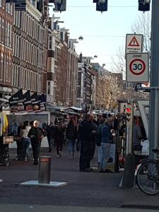 a crowd of people walking down a busy city street at Zoet Amsterdam in Amsterdam