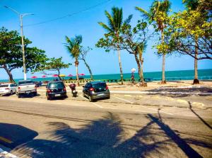 a group of cars parked next to the beach at Guest House Rosa do Mar in Olinda