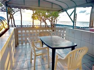 a table and chairs on a balcony with the ocean at Guest House Rosa do Mar in Olinda