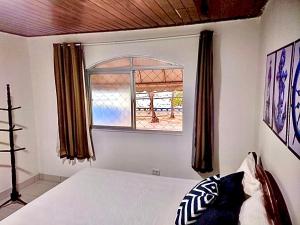 a bedroom with a bed and a window at Guest House Rosa do Mar in Olinda