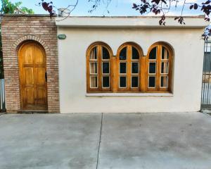 a house with two wooden doors and a driveway at El Gorrión in La Consulta