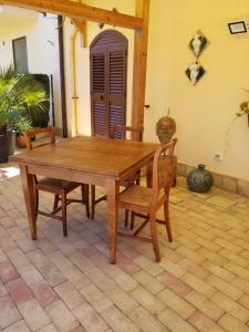 a wooden table and chairs on a patio at AGRIALMA in Agrigento