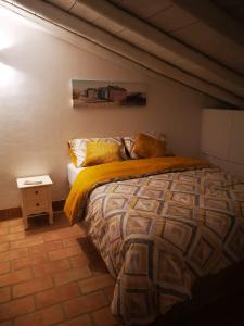 een slaapkamer met een bed met een geel dekbed bij Casa da Vila in Ferragudo