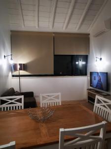 een woonkamer met een projectiescherm en een tafel bij Casa da Vila in Ferragudo