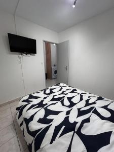 una camera da letto con un letto con un piumone bianco e nero di Appartement à ARGELES SUR MER PLAGE ad Argelès-sur-Mer