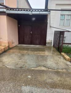 a garage with a brown door in a house at Nicat in Quba