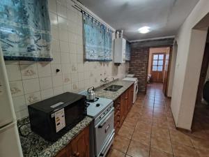 a kitchen with a sink and a stove top oven at El Gorrión in La Consulta