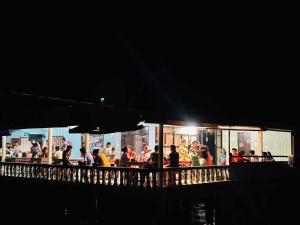 a group of people standing outside a restaurant at night at Happy Fuji Homestay in Ko Phrao Nai