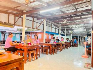 a group of people sitting at tables in a restaurant at Happy Fuji Homestay in Ko Phrao Nai +91 photos