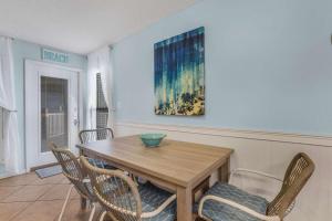 a dining room with a wooden table and chairs at Sandpiper 1C- Stylish Gulf-side affordable in Gulf Shores