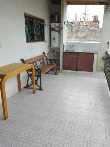 a room with a bench and a table and a kitchen at Casa en la costa in Necochea